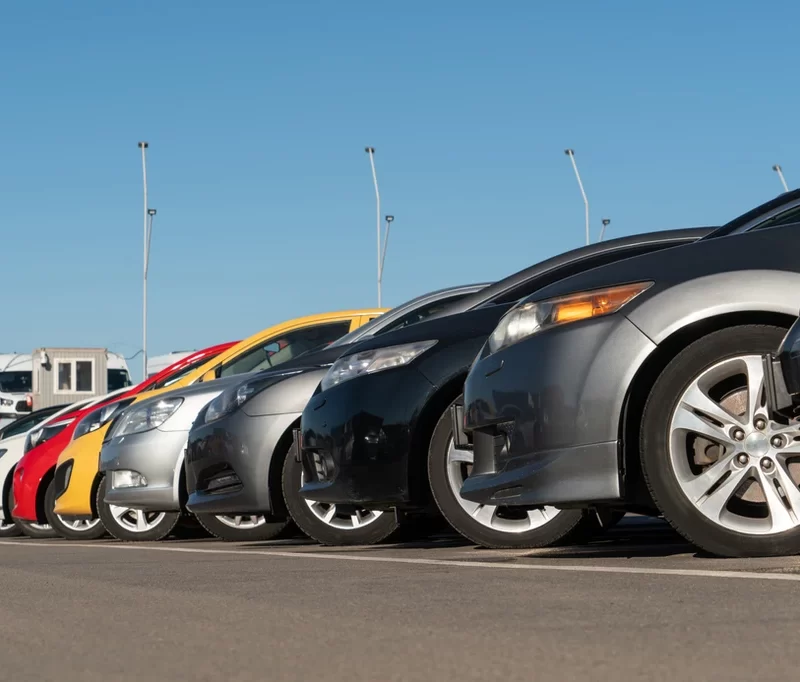 front side view a row of cars parked in a parking lot.